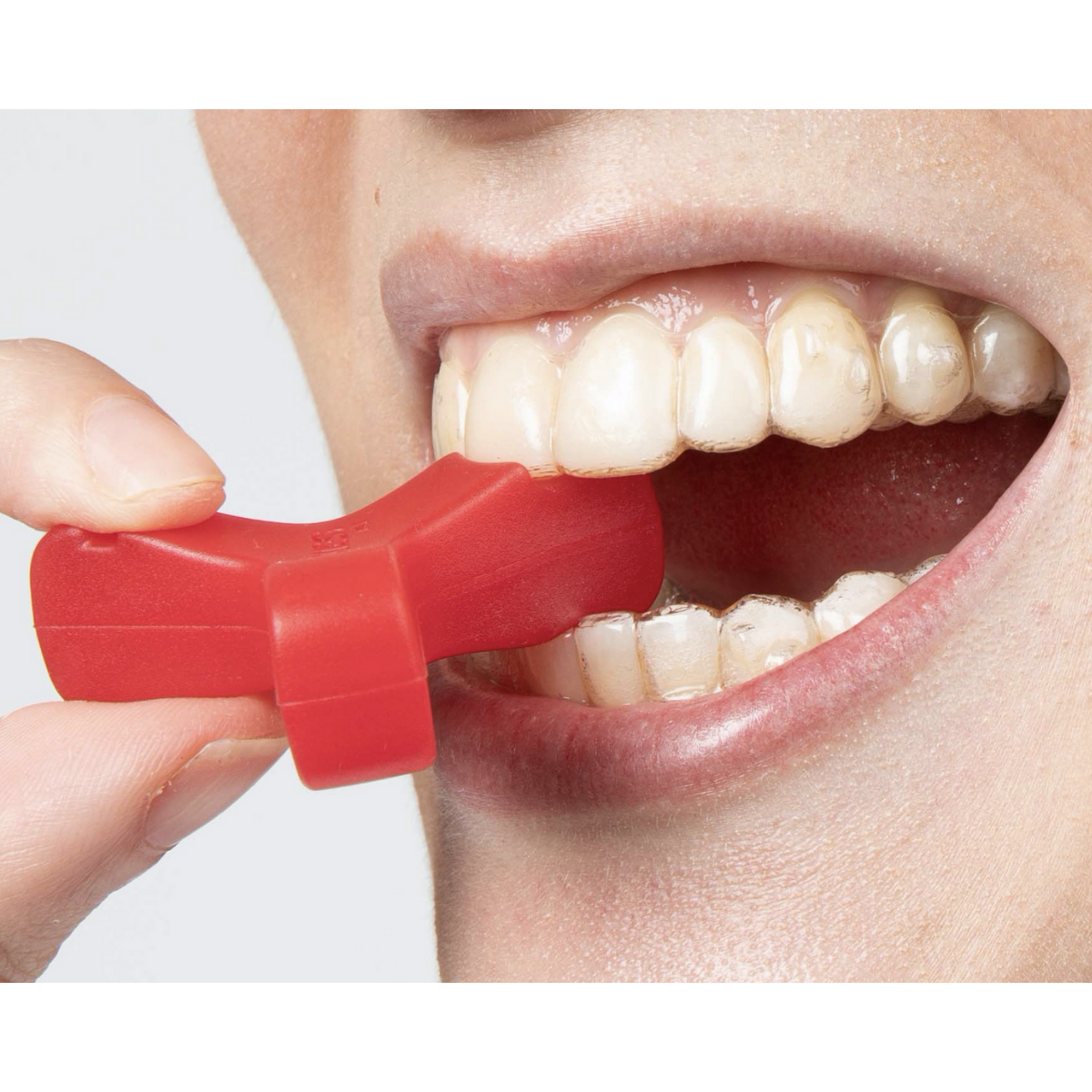 Red Munchies® Maxx in mouth engaged with front tooth