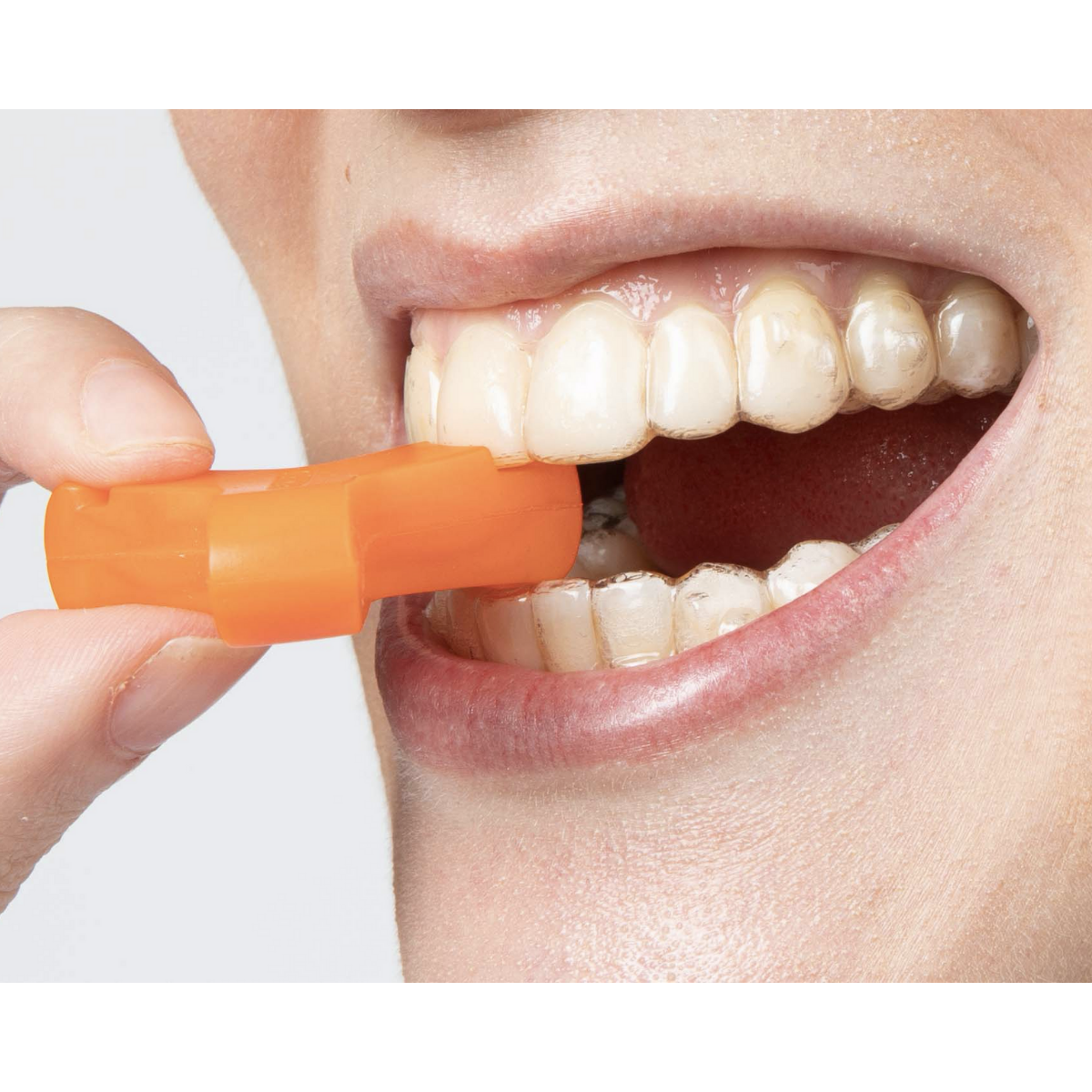 Orange Munchies® engaged with top teeth